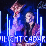 Dshini Ignis auf seiner Bühne, ein Schriftzug "Twilight Cabaret"