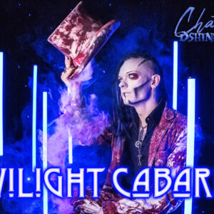 Dshini Ignis auf seiner Bühne, ein Schriftzug "Twilight Cabaret"